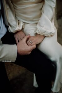Couple showing lab-grown diamond ring + wedding band