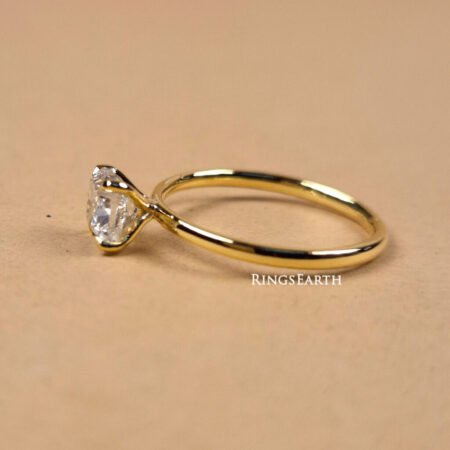 Side angle of cushion cut EF VS1 lab diamond ring with minimalist prong setting in 18K yellow gold