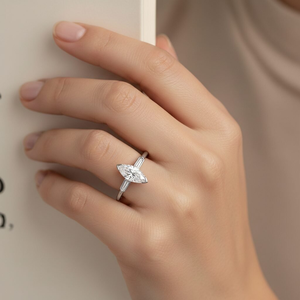 Marquise cut diamond engagement ring in yellow gold worn on a woman's hand