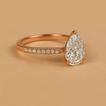 Side pose pear-shaped diamond engagement ring with side stones