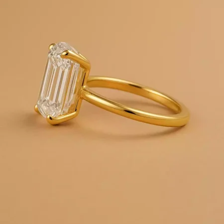 Side profile of emerald cut 6ct lab diamond solitaire ring in yellow gold – four-prong minimal design
