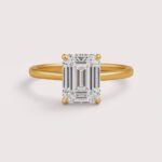Emerald cut 6 carat lab diamond solitaire ring in 18K yellow gold – front view on matte background