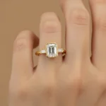 Front view of three-stone engagement ring with emerald cut center diamond and baguette sides in white gold