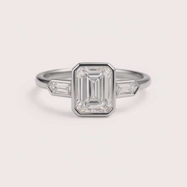 Front view of three-stone engagement ring with emerald cut center diamond and baguette sides in white gold