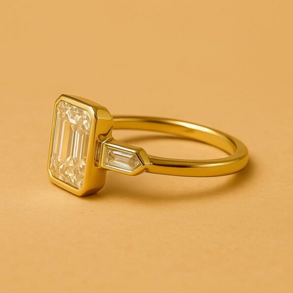 Side profile of yellow gold ring featuring emerald cut center diamond and tapered baguette side stones
