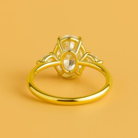 Underside view of a three-stone engagement ring showing prong and basket setting details in yellow gold.