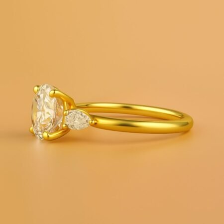 Side profile of a round brilliant cut diamond ring with pear-shaped accents in yellow gold band.
