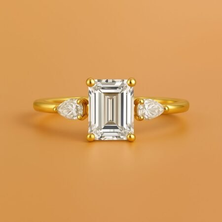 Emerald cut lab-grown diamond engagement ring with pear side stones in yellow gold, front view.
