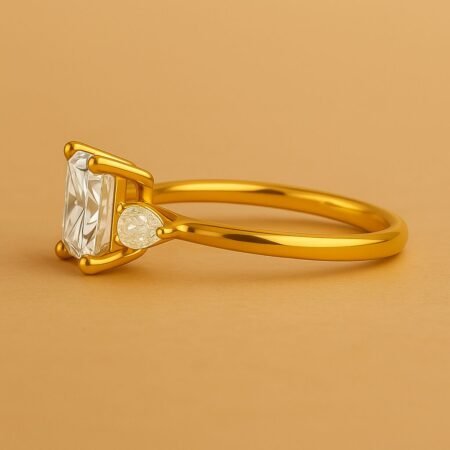Side profile of a princess cut diamond ring with pear side diamonds set in yellow gold, straight shank.