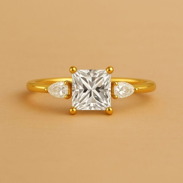 Front view of princess cut lab-grown diamond ring with pear side stones, classic yellow gold setting.