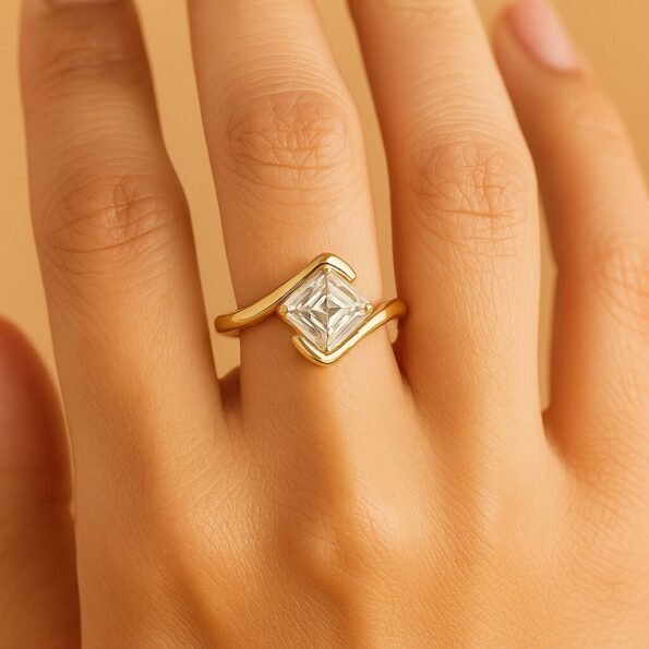 Model hand wearing an Asscher cut diamond solitaire bypass ring in yellow gold