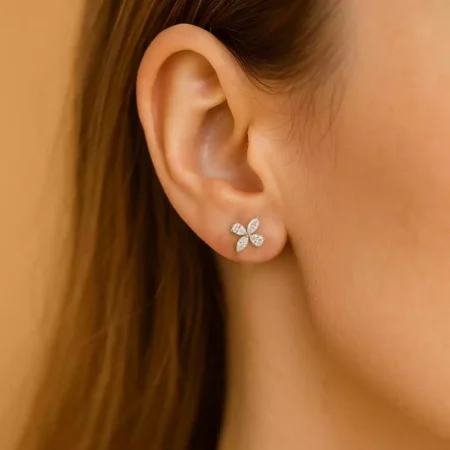 Woman wearing floral cluster lab-grown diamond stud earrings in white gold – close-up ear view