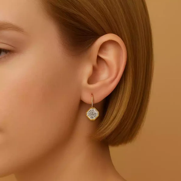 Woman wearing Asscher -shaped bezel-set lab-grown diamond drop earring in yellow gold – elegant close-up