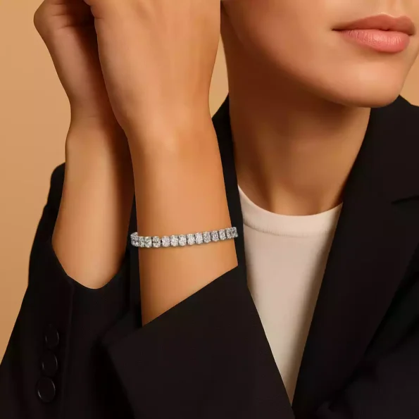 Woman wearing oval lab-grown diamond bracelet in white gold – stylish wrist view with formal outfit